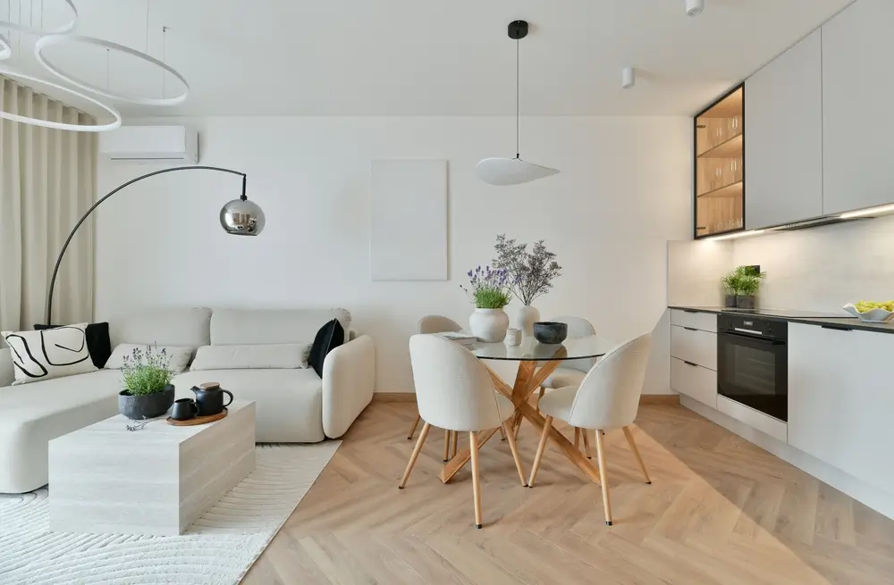 Photo de salon moderne à Abonnement ouvert avec style japonais, canapé blanc, lustre à anneaux Led, parquet en arête de hareng et cuisine équipée minimaliste.