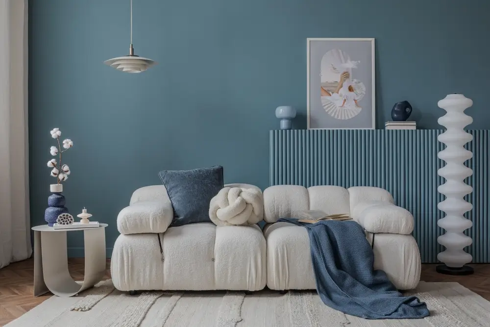 Intérieur minimaliste avec un canapé bouclé, des accents bleus et un décor artistique, créant une atmosphère paisible et élégante.